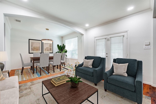 living room with ornamental molding, arched walkways, baseboards, recessed lighting, and wood finished floors
