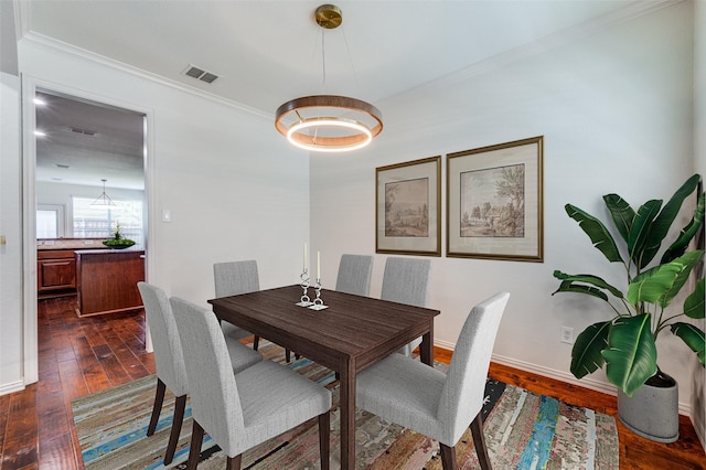dining space featuring ornamental molding, dark wood-type flooring, and baseboards