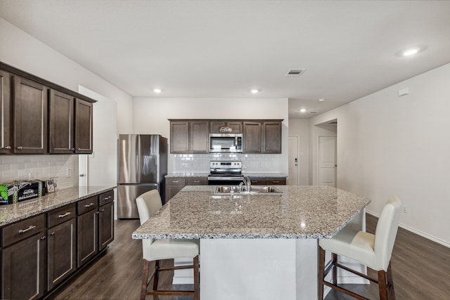 3936 Burks Ct, Celina, TX 75009 - kitchen featuring black appliances, a sink, arched walkways, light tile patterned floors, and dark stone counters