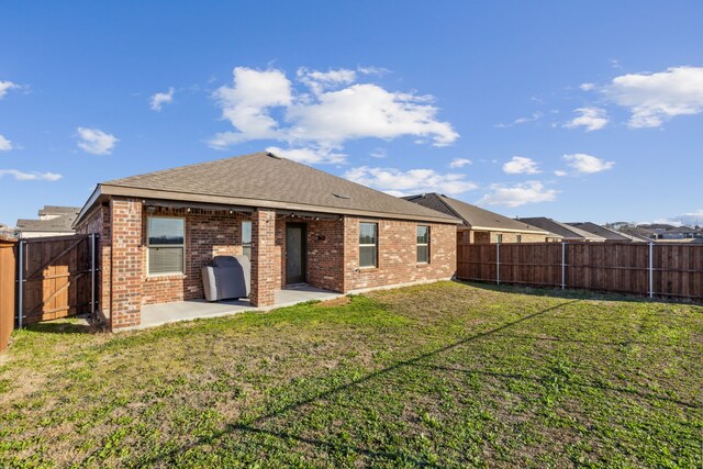 3936 Burks Ct, Celina, TX 75009 - back of property with brick siding, a patio area, and roof with shingles