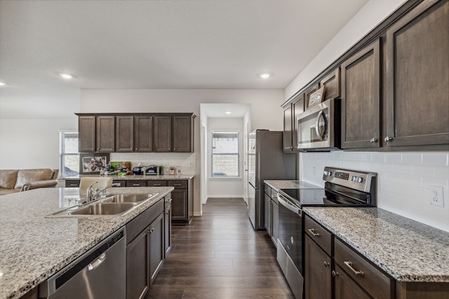 3936 Burks Ct, Celina, TX 75009 - kitchen featuring stainless steel appliances, a sink, dark brown cabinets, healthy amount of natural light, and recessed lighting