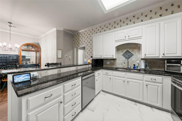 209 Village Cir, Waco, TX 76710 - kitchen with appliances with stainless steel finishes, a sink, a chandelier, a peninsula, and white cabinets