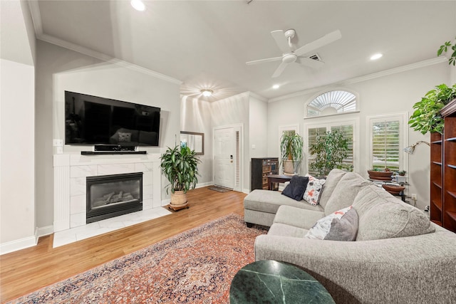 209 Village Cir, Waco, TX 76710 - living room with wood finished floors, a ceiling fan, ornamental molding, recessed lighting, and a tiled fireplace