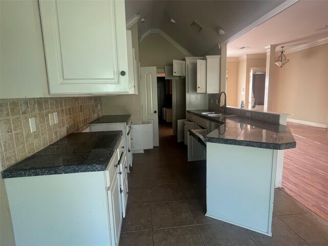 2127 Forest Hills Blvd, Haughton, LA 71037 - kitchen with a peninsula, a sink, dark countertops, white cabinets, and dark tile patterned flooring