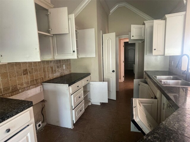 2127 Forest Hills Blvd, Haughton, LA 71037 - kitchen with a sink, lofted ceiling, white cabinetry, dark tile patterned flooring, and decorative backsplash