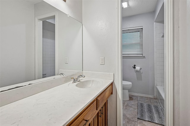 bathroom featuring toilet, vanity, and baseboards
