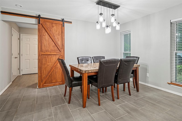 dining area featuring plenty of natural light, a barn door, and baseboards