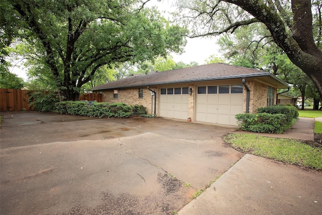 1305 Cliff Dr, Graham, TX 76450 - view of property exterior with fence, an attached garage, and driveway