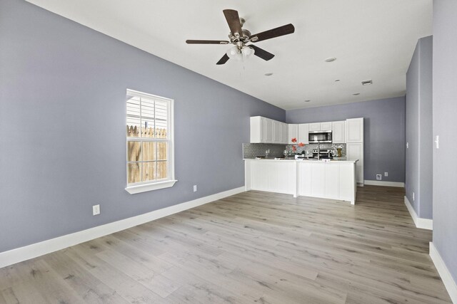 620 S First St, Sherman, TX 75090 - unfurnished living room featuring a ceiling fan, light wood-style floors, baseboards, and lofted ceiling