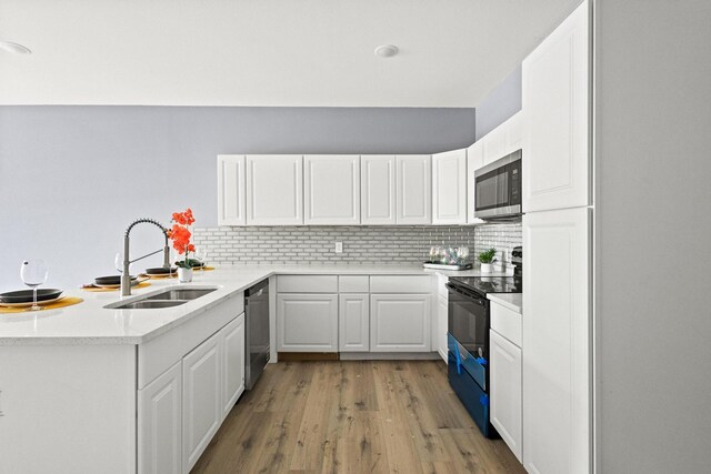 620 S First St, Sherman, TX 75090 - kitchen with appliances with stainless steel finishes, a sink, light wood-style flooring, decorative backsplash, and white cabinets