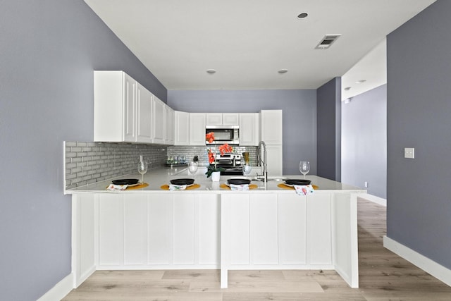 620 S First St, Sherman, TX 75090 - kitchen featuring stainless steel appliances, backsplash, light countertops, baseboards, and a peninsula