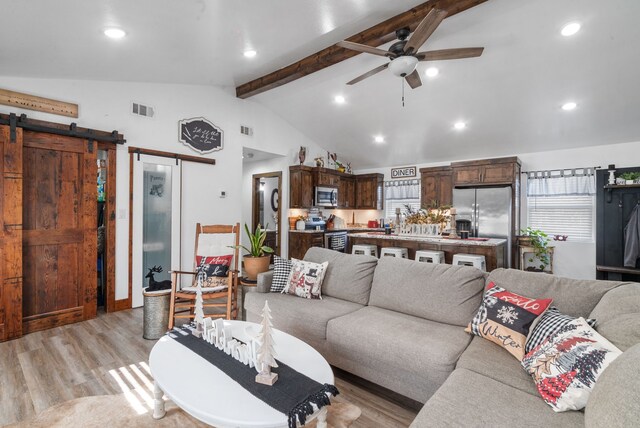 living area with ceiling fan, a barn door, light wood-style floors, healthy amount of natural light, and recessed lighting