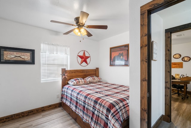 bedroom featuring wood finished floors, baseboards, and a ceiling fan