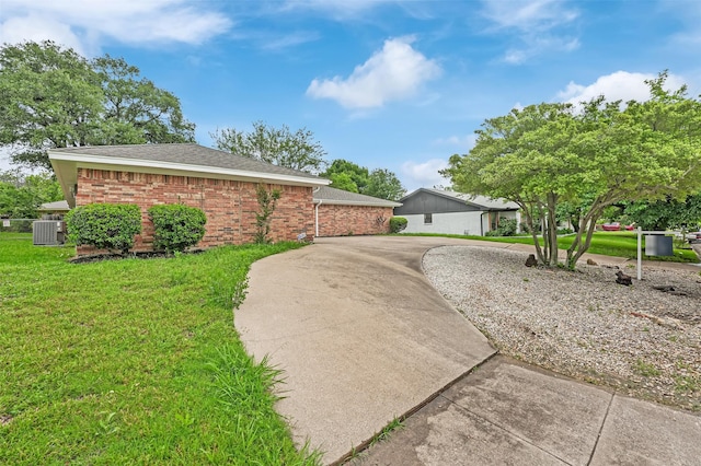 4032 Aragon Dr, Fort Worth, TX 76133 - view of home's exterior with central air condition unit, a lawn, brick siding, and roof with shingles