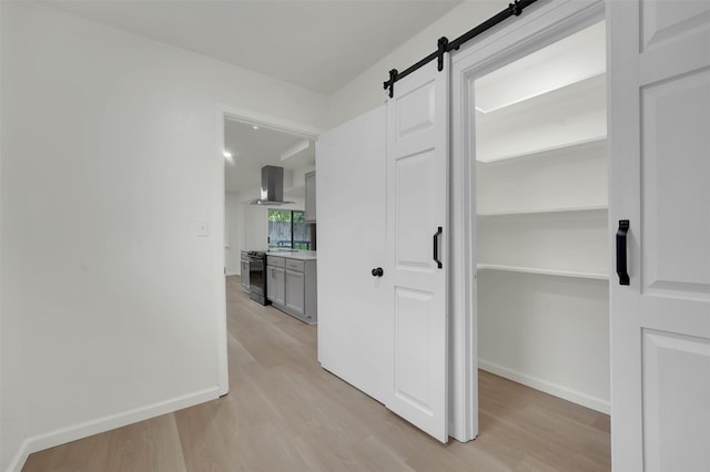 4032 Aragon Dr, Fort Worth, TX 76133 - hallway with a barn door, light wood-style floors, and baseboards