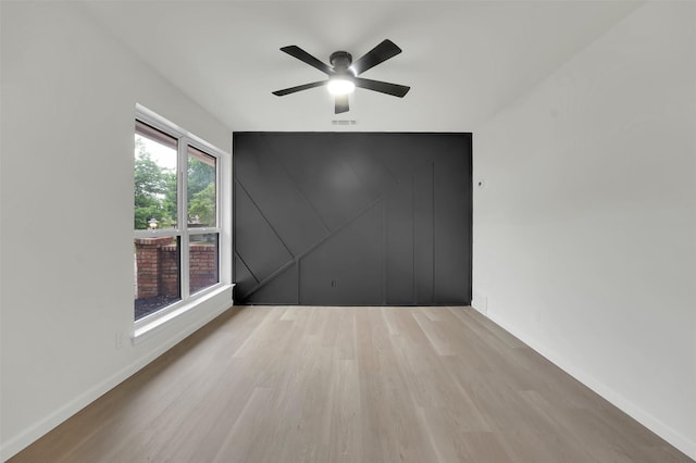 4032 Aragon Dr, Fort Worth, TX 76133 - unfurnished room with wood finished floors, ceiling fan, baseboards, and an accent wall