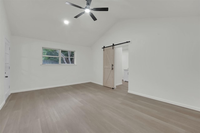 4032 Aragon Dr, Fort Worth, TX 76133 - unfurnished bedroom featuring a barn door, wood finished floors, baseboards, vaulted ceiling, and ceiling fan