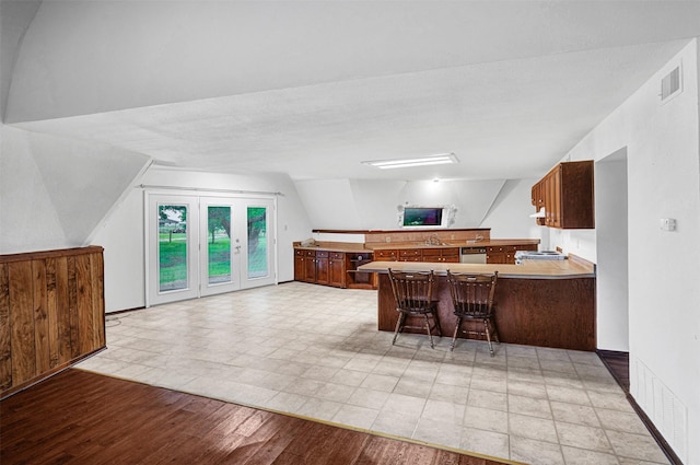 18206 Valley Vw, Forney, TX 75126 - kitchen with a sink, a peninsula, light wood finished floors, a breakfast bar area, and lofted ceiling