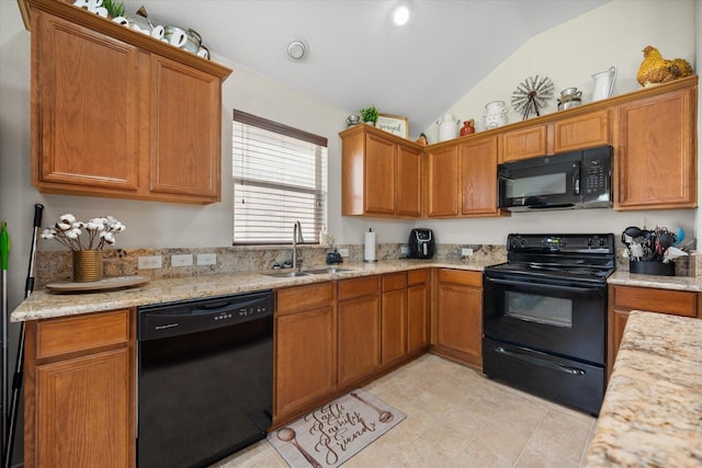 kitchen with black appliances, a sink, vaulted ceiling, brown cabinetry, and light stone counters