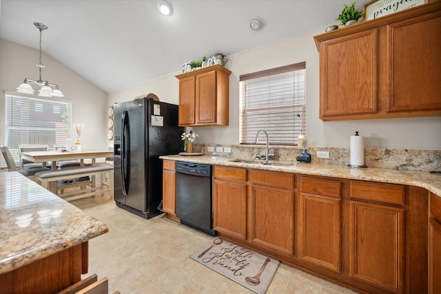 kitchen featuring black appliances, a sink, vaulted ceiling, brown cabinetry, and hanging light fixtures