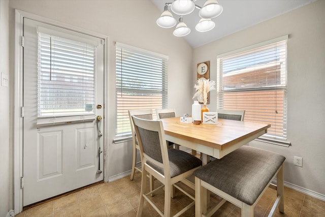 dining room with a chandelier, plenty of natural light, baseboards, lofted ceiling, and light tile patterned floors