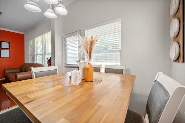 dining space with crown molding and a chandelier