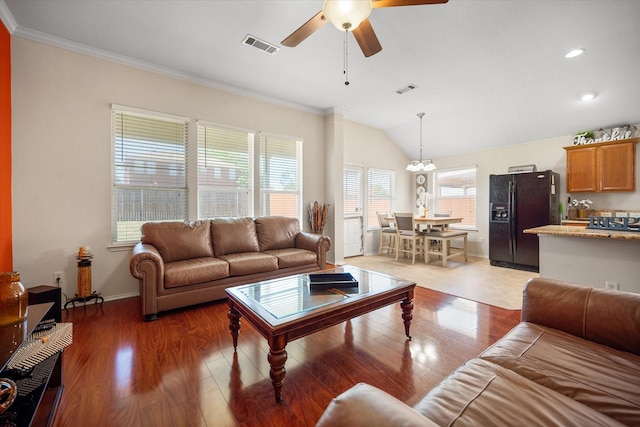 living room with a ceiling fan, ornamental molding, light wood-style flooring, vaulted ceiling, and baseboards