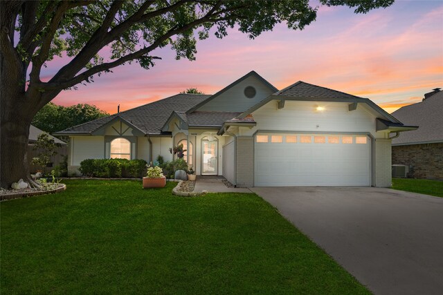 view of front of home with a garage, concrete driveway, a front yard, central air condition unit, and brick siding