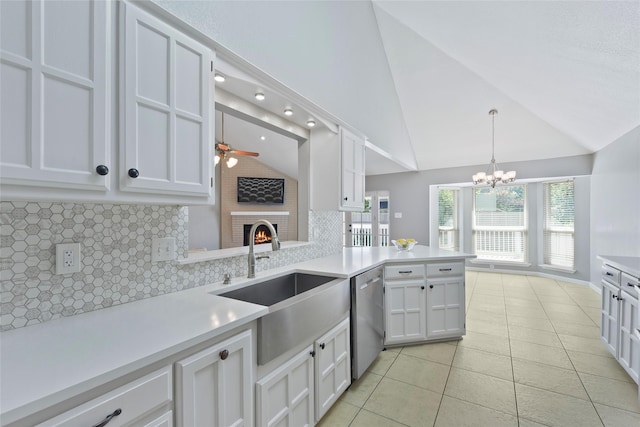 kitchen featuring stainless steel dishwasher, a sink, a ceiling fan, backsplash, and light tile patterned flooring