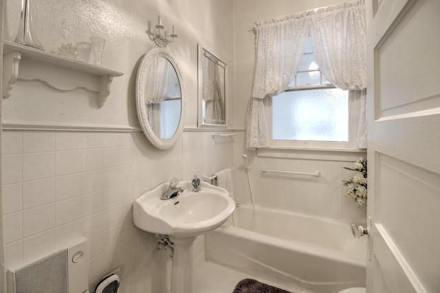 101 E Reed St, Randolph, TX 75475 - full bathroom with a bathtub, tile walls, and a wainscoted wall