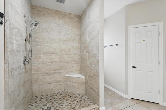 bathroom with tiled shower, tile patterned floors, and baseboards