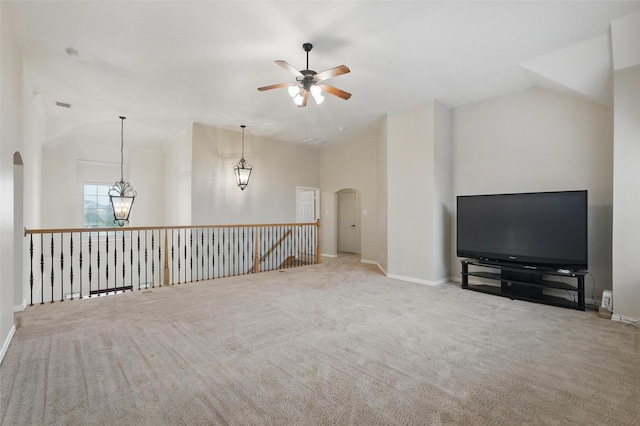 unfurnished living room featuring arched walkways, ceiling fan, carpet, and high vaulted ceiling