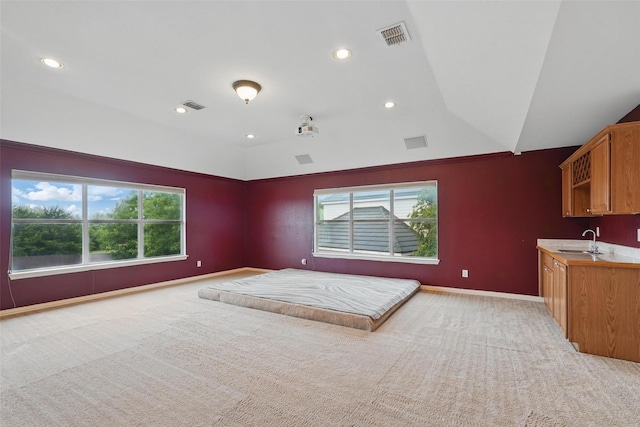 bedroom with a sink, multiple windows, light carpet, recessed lighting, and baseboards