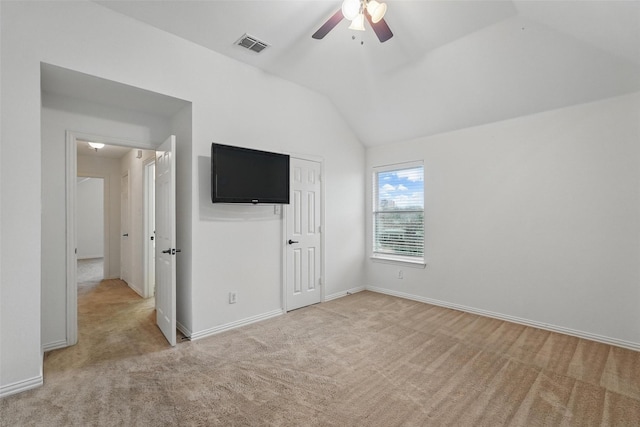 unfurnished bedroom featuring light colored carpet, lofted ceiling, a closet, baseboards, and a ceiling fan