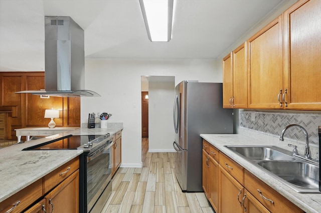 5220 Alpha Dr, The Colony, TX 75056 - kitchen featuring island range hood, appliances with stainless steel finishes, a sink, decorative backsplash, and light wood-style flooring