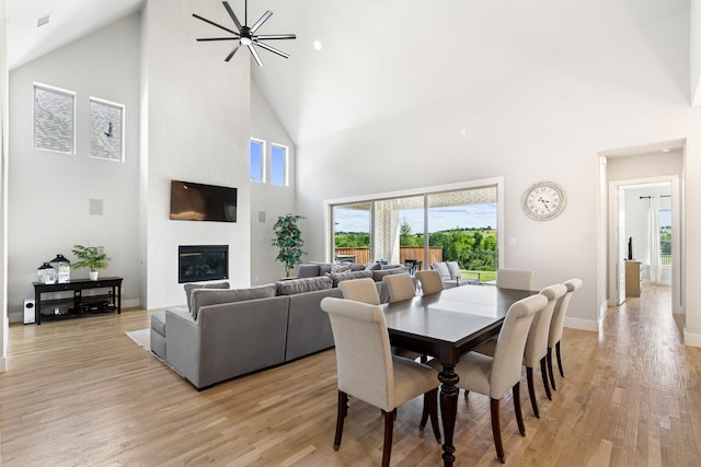 13417 Meadow Cross Dr, Fort Worth, TX 76008 - dining space featuring high vaulted ceiling, a fireplace, light wood-style floors, and plenty of natural light