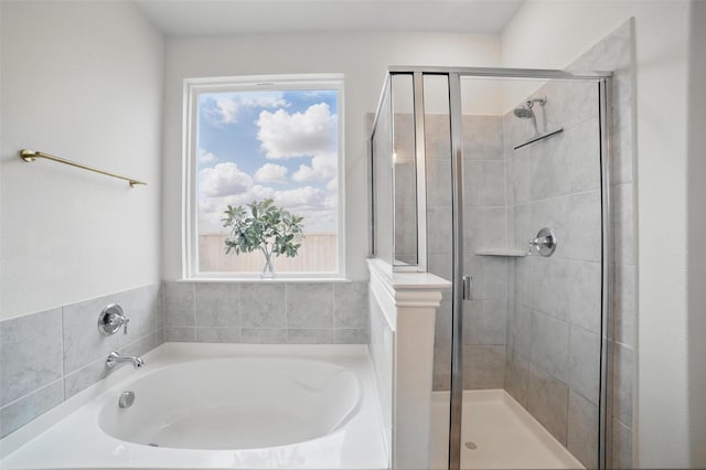 bathroom featuring a shower stall and a garden tub