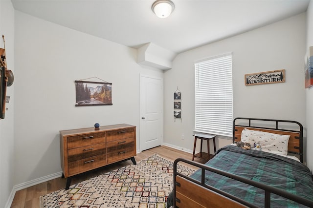 bedroom with light wood-type flooring and baseboards
