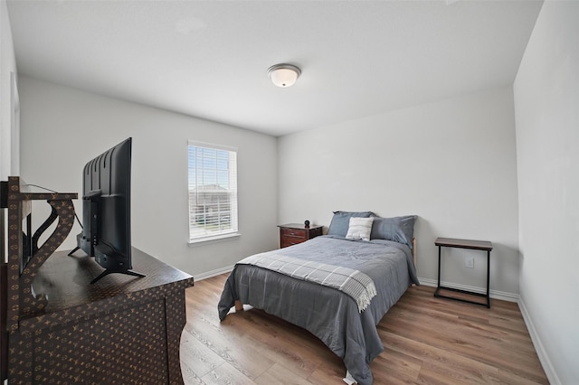 bedroom with wood finished floors and baseboards