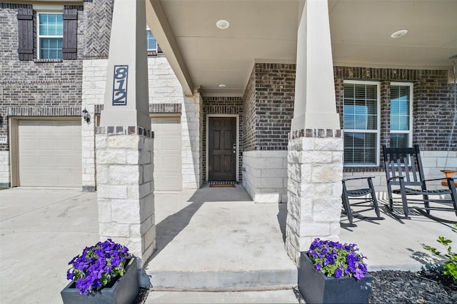 property entrance featuring brick siding, an attached garage, and stone siding