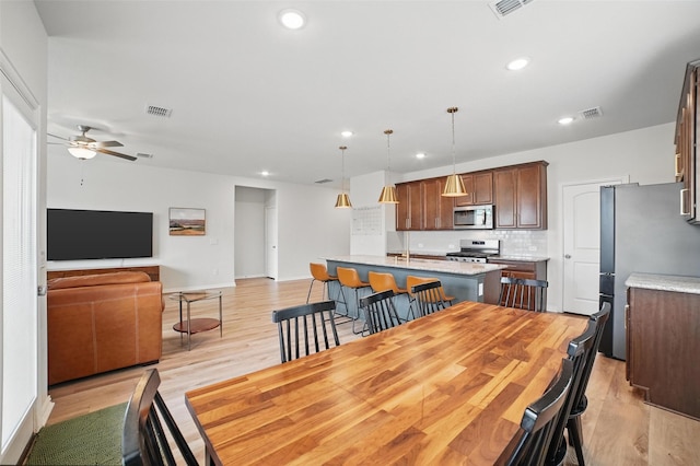 dining room with recessed lighting, ceiling fan, light wood-style floors, and baseboards