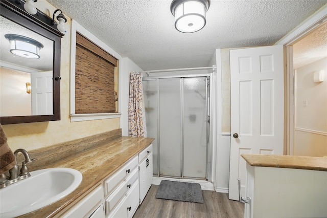 4548 Ivy Dr, Mesquite, TX 75150 - bathroom featuring a textured ceiling, a shower stall, wood finished floors, and vanity