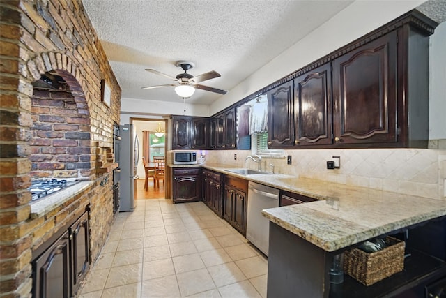 4548 Ivy Dr, Mesquite, TX 75150 - kitchen featuring appliances with stainless steel finishes, a sink, a textured ceiling, ceiling fan, and decorative backsplash