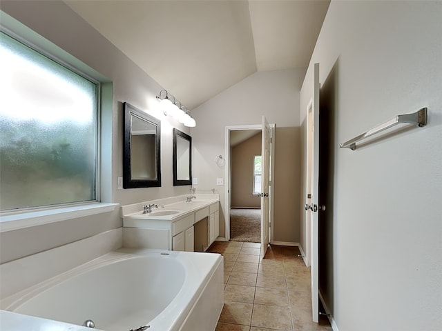 full bath featuring lofted ceiling, tile patterned flooring, double vanity, a bath, and baseboards