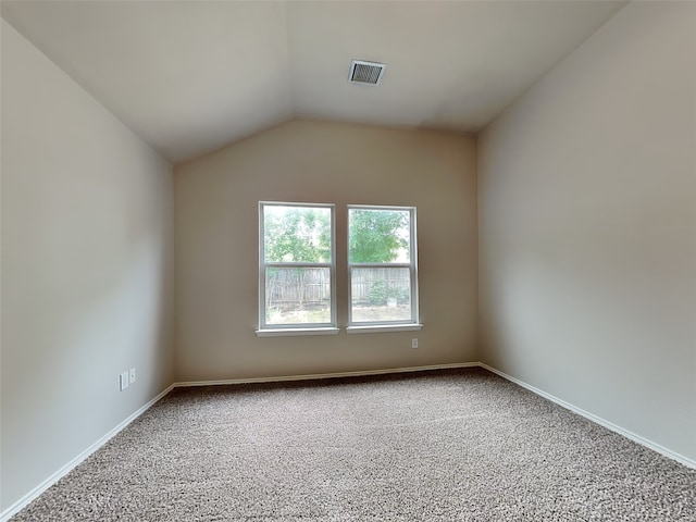 empty room with carpet floors, lofted ceiling, and baseboards