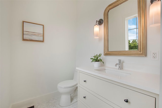 bathroom with vanity, toilet, and baseboards