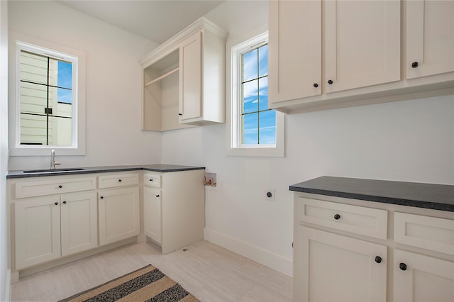 laundry area featuring cabinet space, baseboards, hookup for a washing machine, light wood-style flooring, and hookup for an electric dryer