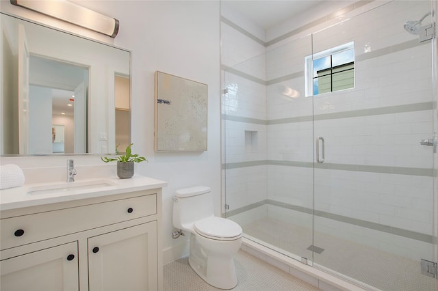 bathroom with a stall shower, toilet, vanity, and tile patterned floors