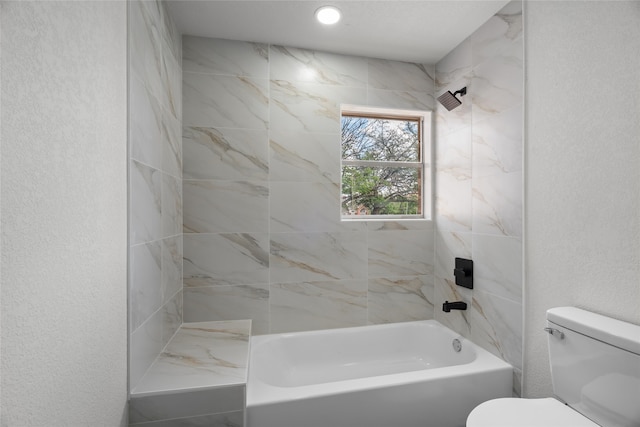 118 Mockingbird Ln, Hillsboro, TX 76645 - bathroom featuring toilet, bathing tub / shower combination, and a textured wall
