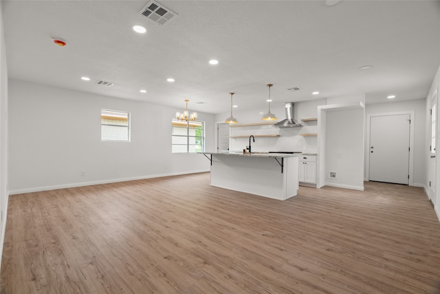 118 Mockingbird Ln, Hillsboro, TX 76645 - kitchen featuring open shelves, a breakfast bar area, light wood finished floors, recessed lighting, and a sink